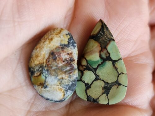 Two hand-polished 22-karat vintage Tibetan turquoise cabochons displaying natural matrix patterns and weathered patina, gemstone specimens for jewelry making שני קבושונים טורקיז טיבטי ישן בליטוש ידני 22 קארט עם דוגמות מטריקס טבעיות וקורוזיה בשל הגיל, אבני חן לעיצוב תכשיטים